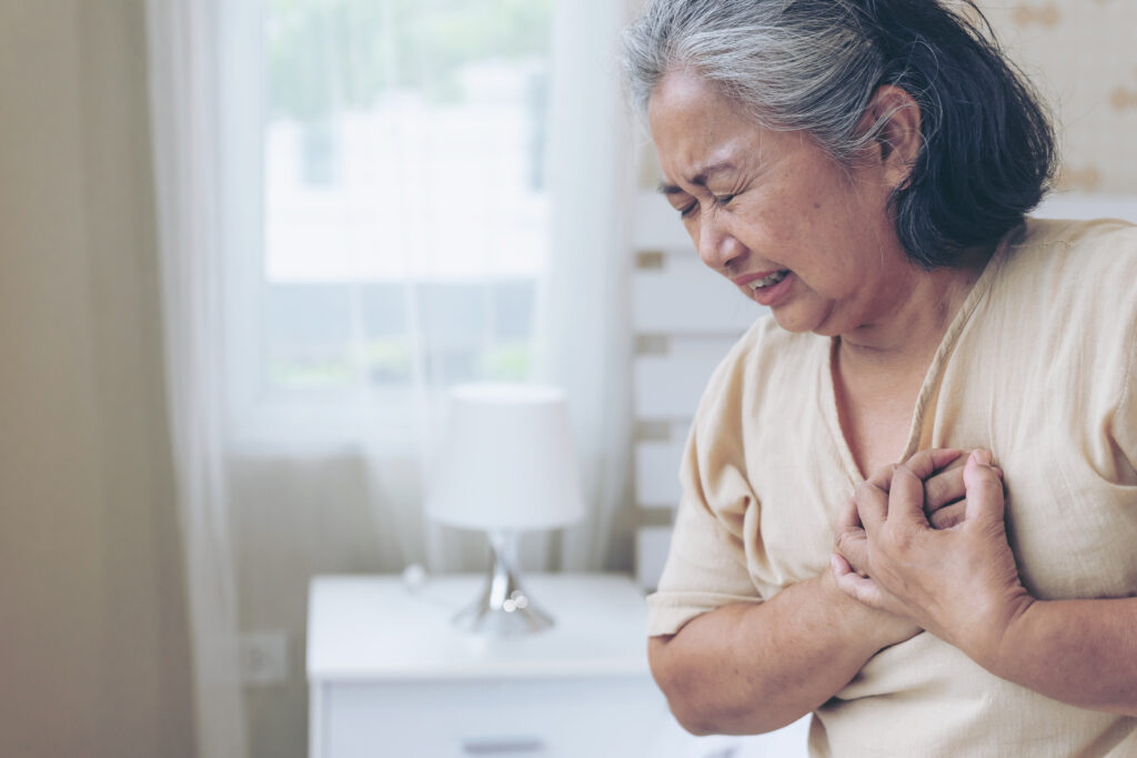Senior female Asian suffering from bad pain in his chest heart attack at home - senior heart disease
