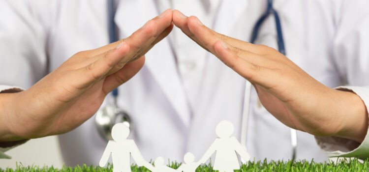 Close up picture of doctor's hands posting symbol of home above family member model
